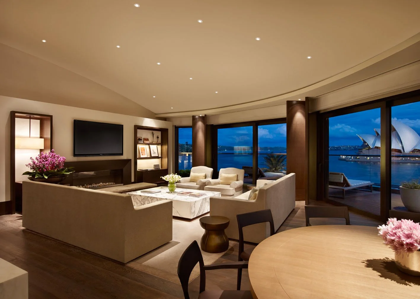 The Sydney Suite lounge room at night, with the Opera House illuminated through the window.